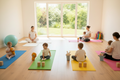 Mommy & Me yoga class with mothers and babies on colorful mats in a bright modern studio